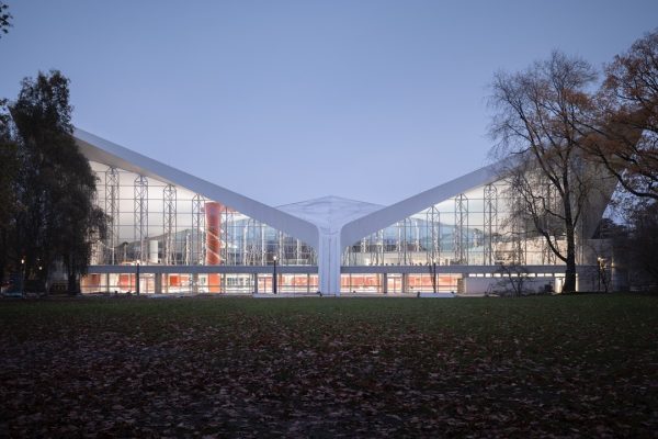 Modernes Gebäude mit Glasfront und weißem Flügeldach als Beispiel für Nachhaltigkeit im Bauwesen.