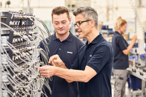 Mitarbeiter bei technischer Verkabelung fördern GEZE Sozialstandards Nachhaltigkeit Ecovadis im Betrieb.
