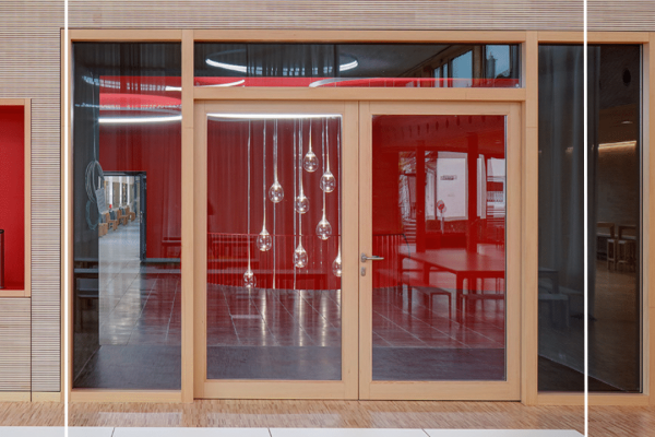 Moderne Holztür mit Festverglasung sorgt für eine transparente und offene Atmosphäre im hellen Innenraum.