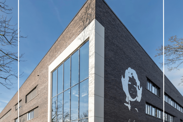 Moderne Außenansicht der Schule Lore Lorentz mit dunkler Klinkerfassade, großer Glasfront und Porträtgrafik.