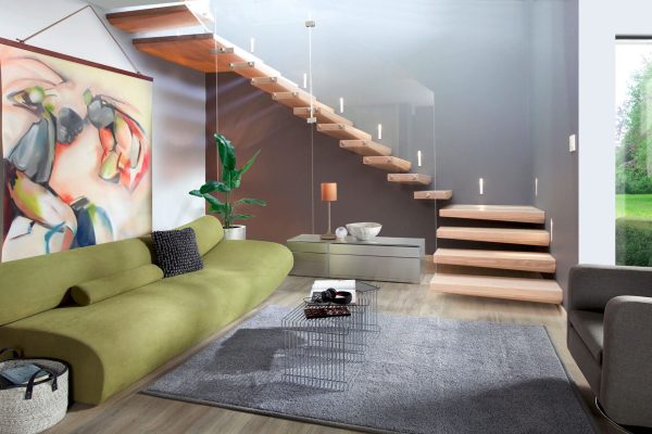 Moderne Holztreppe Treppenmeister Ego mit Glas und Wandbeleuchtung in einem hellen Wohnzimmer.