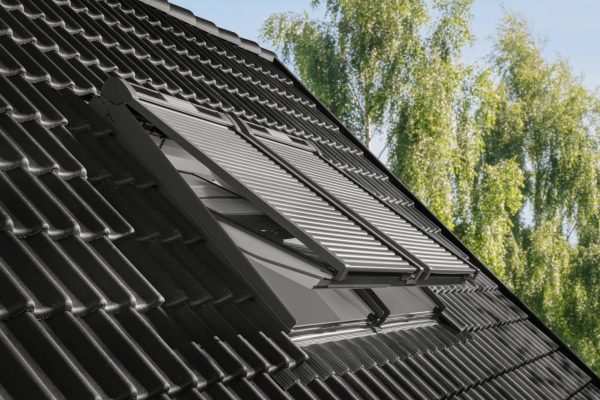 Velux Rollläden auf dem Flügel eines Dachfensters montiert für unabhängige Bedienung auf dunklem Ziegeldach.