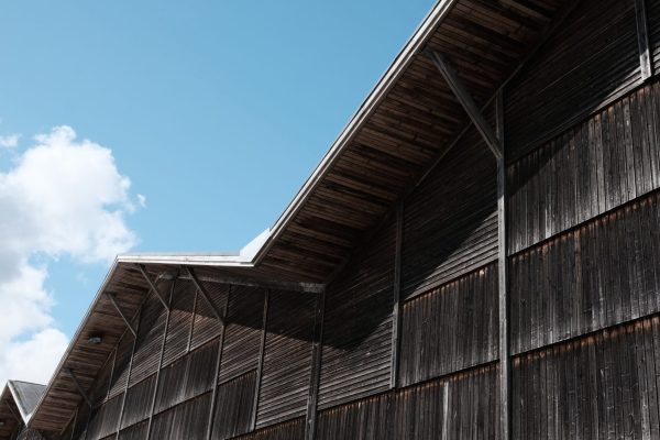 Dunkle Holzfassade mit markantem Zickzack-Dach am LKR Innovation House Bestand 2 vor blauem Himmel.