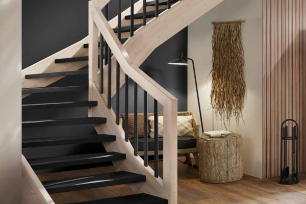 Moderne Holztreppe mit schwarzen Stufen und hellem Holzgeländer in einem offen gestalteten Wohnzimmer.