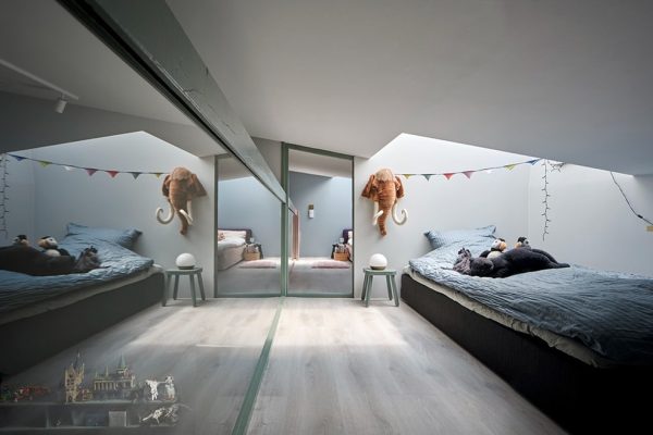Modernes Kinderzimmer im ADA House mit Bett unter der Dachschräge und Spiegelwand von mencke&vagnby.