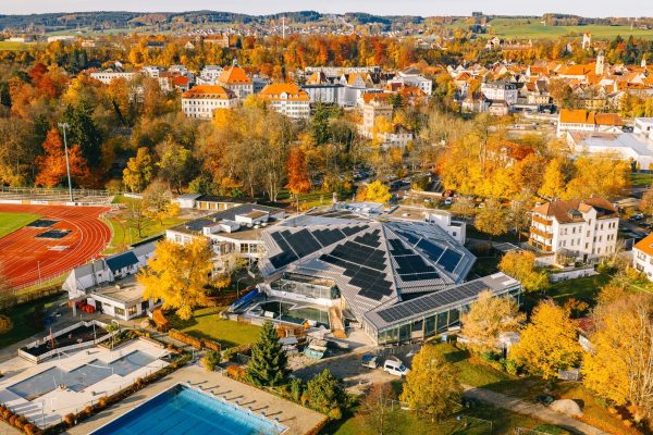 Saniertes BEMO Stehfalzdach mit Photovoltaik auf dem Jordan Badepark Kaufbeuren in herbstlicher Umgebung.