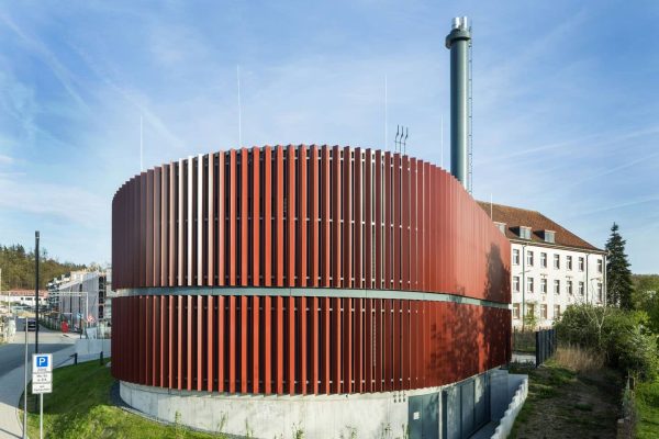 Runde Aluminium-Lamellenfassade der Entega Energiezentrale mit markanten roten vertikalen Lamellen aus Metall.