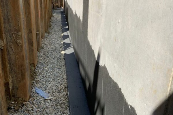 Bauwerksabdichtung an einer Betonwand im Multipark Schrobenhausen in einer Baugrube mit Kies und Spundwand.