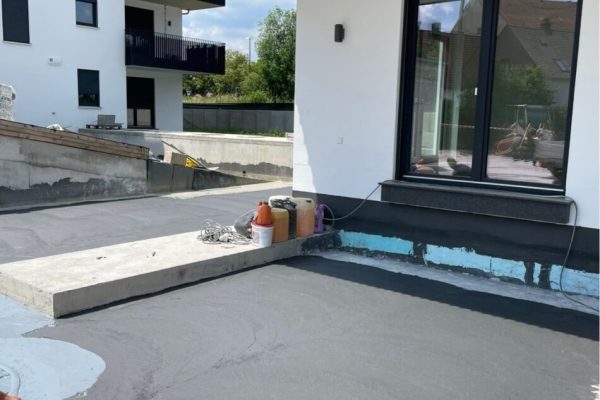 Präzises Auftragen einer grauen Beschichtung zur Flächenabdichtung auf Beton im Multipark Schrobenhausen.