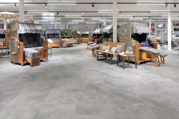 Der Vinyl-Designbelag Dekor ST 941 (floors@work) von Project Floors in Betonoptik schafft im Showroom der Strandkorbprofis eine zurückhaltende, moderne Bühne für die Ausstellung.