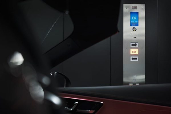 Moderner CARRICO Autoaufzug im AMG Brand Center mit digitalem Bedientableau und Anzeige für das Erdgeschoss.
