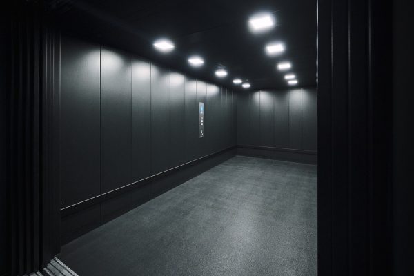CARRICO Autoaufzug mit schwarzer Folierung und LED-Beleuchtung im modernen Innendesign des AMG Brand Centers.