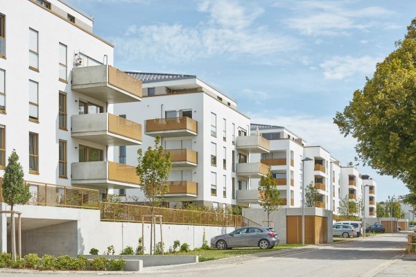 Moderne Wohnanlage Ludwigsburg mit weißen Fassaden und goldfarbenen Balkongittern aus Lochblech.