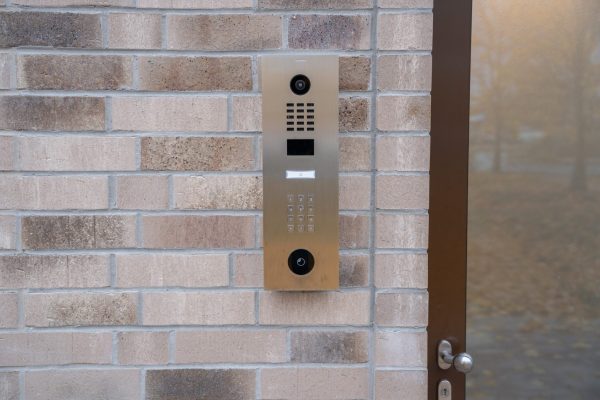 Moderne Video-Türstation mit Kamera und Keypad an der Klinkerfassade am Nebeneingang für sichere Zutrittskontrolle.