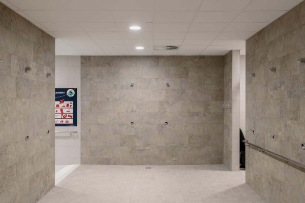 Moderner Duschraum mit beigen Fliesen und dem bodengleichen Dallmer Ablauf DallDrain für optimale Entwässerung.