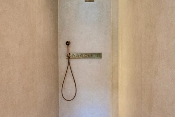 Moderne beige Walk-in-Dusche mit Armaturen und dem Entwässerungssystem DallFlex 2.0 als flache Duschrinne.