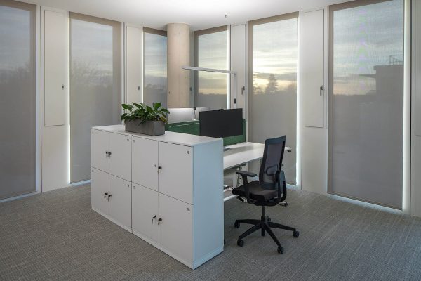 Moderner Büro-Arbeitsplatz im Deichmann Campus mit Sonnen- und Blendschutz bei tiefstehender Sonne.