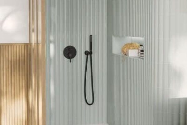 Moderne Dusche mit hellgrünen Fliesen und dem Ecora Einbau Sockel in eleganter grauer Terrazzo-Optik.