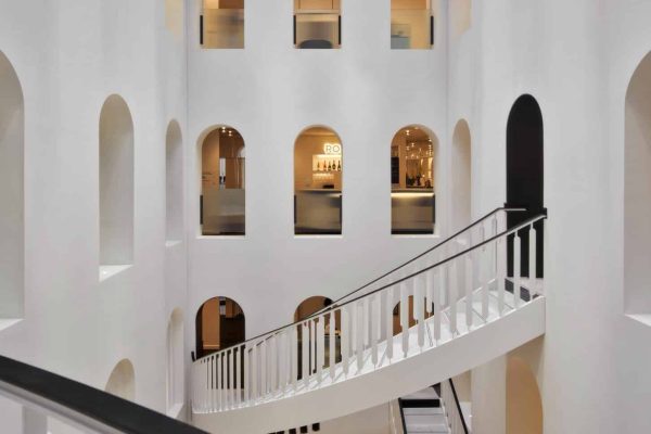 Weiße Wendeltreppe im Atrium sorgt für ein exklusives Ambiente nach ökologisch konzipierten Renovierungsarbeiten.