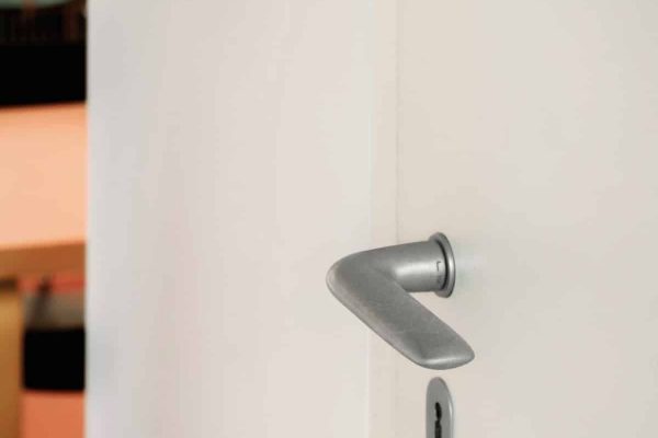 Moderner FSB 1292 Türdrücker aus Aluminium an einer weißen Tür im Café Tiergarten Berlin.