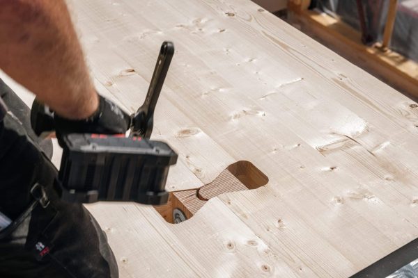 Präzise montierter Hilti HTC-P2P Brettsperrholzverbinder in einer hellen Massivholzplatte für stabile Holzverbindungen.