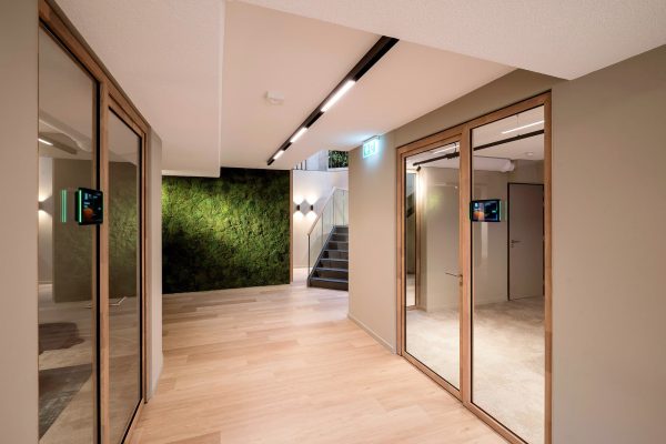 Fugenfreies Deckensystem OWAplan im modernen Büro von Nikkels Twello mit Mooswand, Glaswänden und Holzboden.