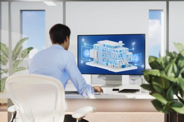 Eine Person am Schreibtisch steuert vernetzte Tür- und Fenstersysteme über ein 3D-Modell mit myGEZE Control.