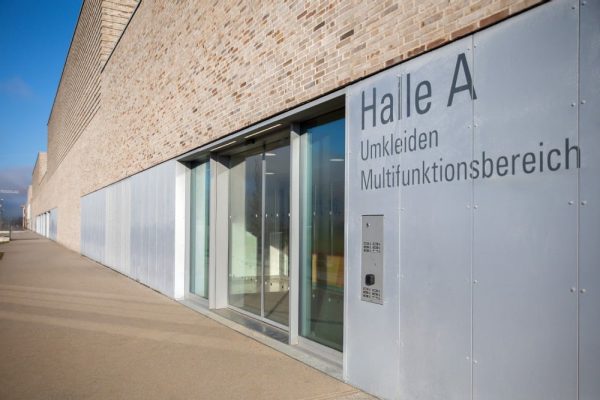 Smarte Gebäudeautomation am Halleneingang mit Zutrittskontrolle und automatischer Türsteuerung für Barrierefreiheit.