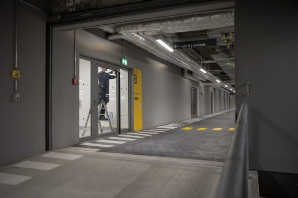 Techniker führt Gebäudeautomation Wartung an einer Automatiktür im Sportpark Freiham für maximale Betriebssicherheit durch.