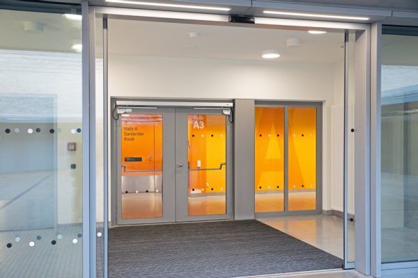 Moderne Glastüren im Sportpark Freiham mit Gebäudeautomation myGEZE Control für vernetzte Türtechnik.