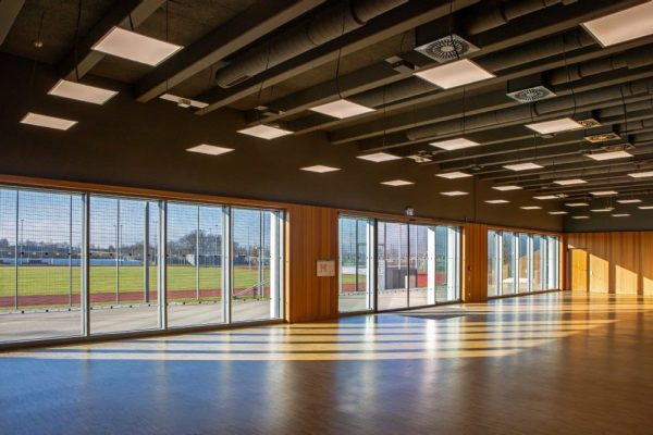 Moderne Sporthalle im Sportpark Freiham mit Gebäudeautomation für energieeffiziente Lüftung und Außenanlagen.