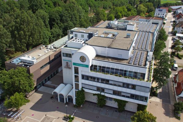 Vogelperspektive auf das Hansgrohe Headquarter in Schiltach mit nachhaltigen Solaranlagen auf dem Gebäudedach.