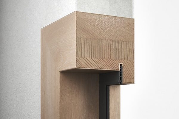 Detailaufnahme einer massiven Holz-Stockzarge im Querschnitt an einer hellen Wand mit Dichtungsprofil.