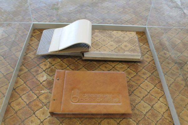 Historischer Bodenbelag im Kaufhaus Zeeck und ein Musterbuch der Dessauer Bodenbeläge in einer Glasvitrine.