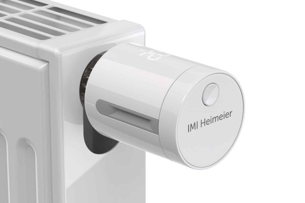 Weißer Heizkörper mit smartem IMI neo-K Thermostat-Kopf von IMI Heimeier und moderner Digitalanzeige.