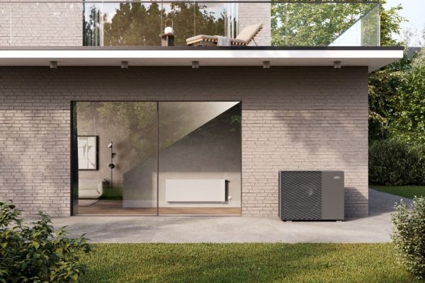 x-change dynamic eco und x-flair Wärmepumpenheizkörper an einem modernen Wohnhaus mit Garten.