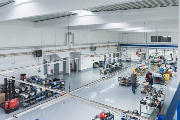 Helle Industriehalle mit glänzendem ESD-Beschichtungssystem, Arbeitstischen und Lagerregalen ganzheitlich betrachtet.