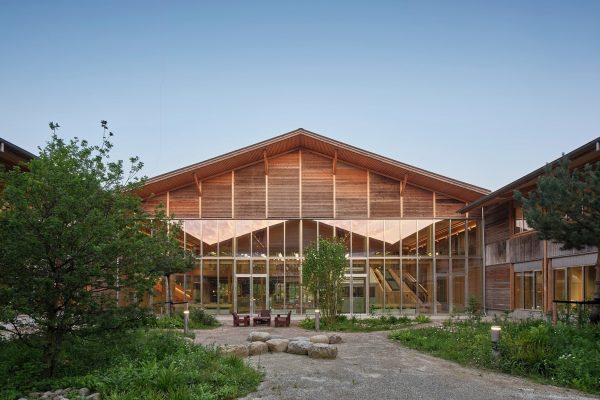 Moderner LKR Innovation House Innenhof mit nachhaltiger Holzarchitektur, Glasfront und grüner Außenanlage.