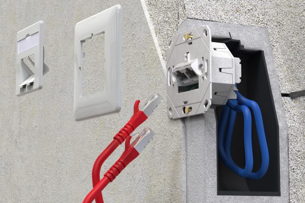 Anschlussdose E-DAT C6A IDC von METZ CONNECT installiert in einer Wand mit blauen Verlegekabeln.