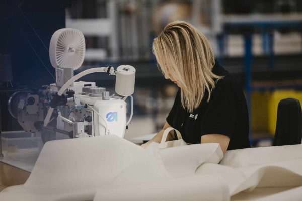 Näherin verarbeitet an der Nähmaschine sorgfältig Glatz Stoffbezüge mit integriertem UV-Schutz.