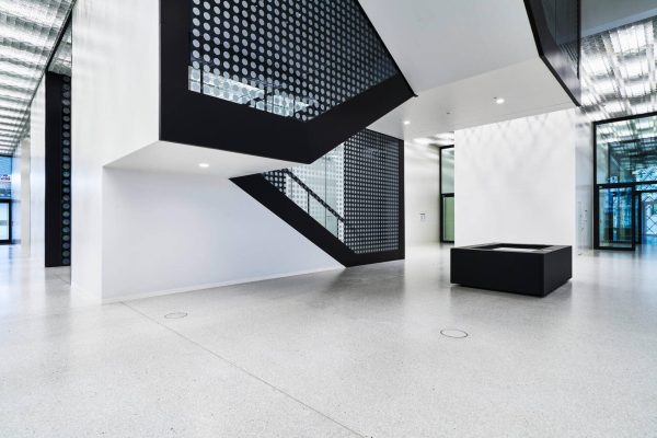 Moderne Architektur im Futurium Berlin mit markanter schwarzer Treppe und hellem, minimalistischem Design.