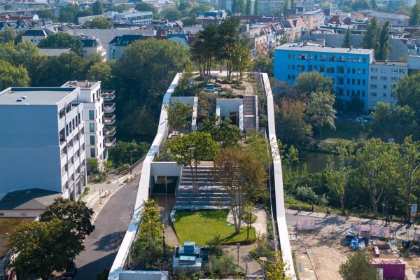 Intensiv begrüntes Dach mit Bäumen und Wegen am Optigrün Referenzprojekt Bürogebäude AERA in Berlin.