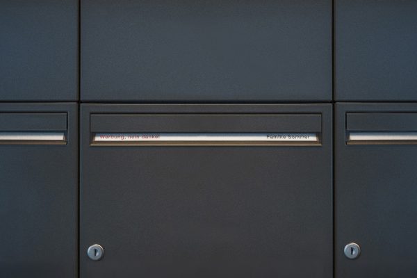 RENZ Flächenbündige Klappe RFBK in Anthrazit mit Namensschild, flächenbündig verbaut in einer Briefkastenanlage.