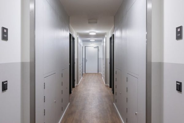 Moderner Flur mit PRIOWALL Brandschutzelementen in den Wänden und einem hellen Holzboden.