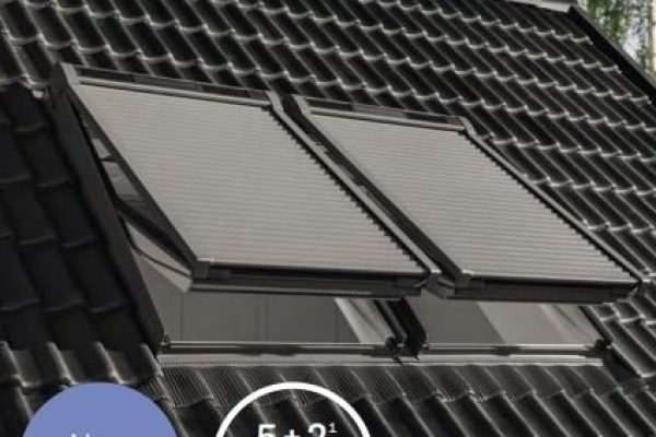 Moderne Rollladen-Generation auf Dachfenstern eines dunklen Ziegeldachs für effektiven Sonnenschutz.