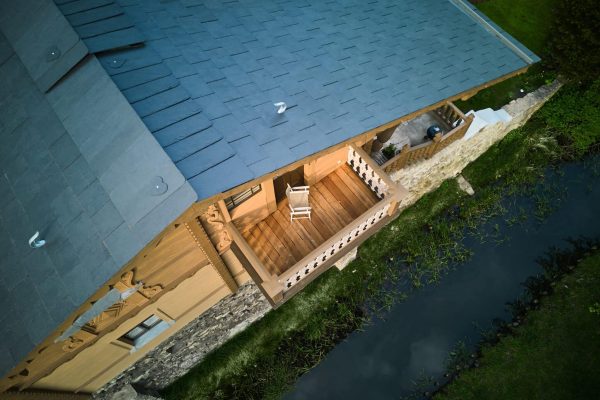 Schweizer Holzhaus mit Balkon und einer neuen Dachfläche aus rechteckigen Rathscheck Schiefersteinen.