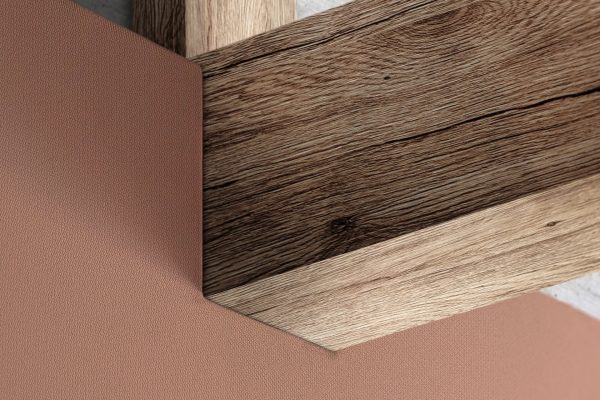 Sonic-Unity Detailaussparung für einen Holzbalken an einer terracottafarbenen Wandfläche vor Sichtbeton.