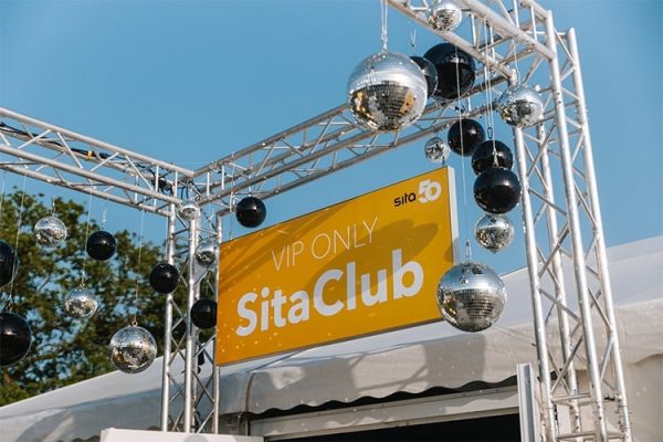 Gelbes VIP ONLY Schild im SitaClub mit silbernen und schwarzen Discokugeln an einer Traverse befestigt.