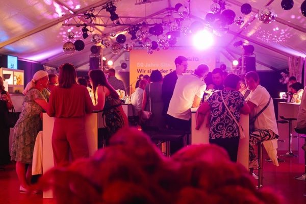 Gäste feiern das 50. Jubiläum von Sita bei einer VIP-Aftershowparty in einem festlich beleuchteten Zelt.
