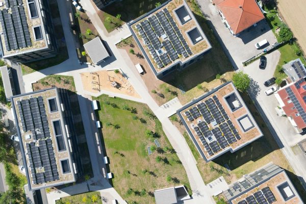 Moderne Wohnanlage Naturella von oben mit Photovoltaik auf Gründächern und gepflegten Wegen.